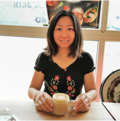 Headshot of Meng with a cup of cappuccino