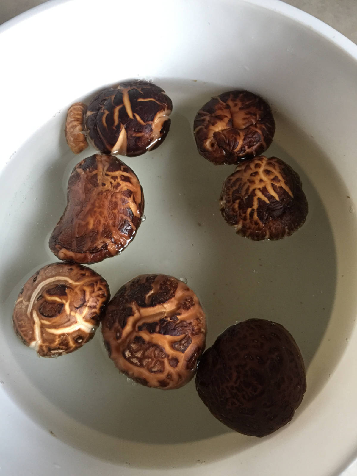shiitake mushrooms soaked in water in a white container