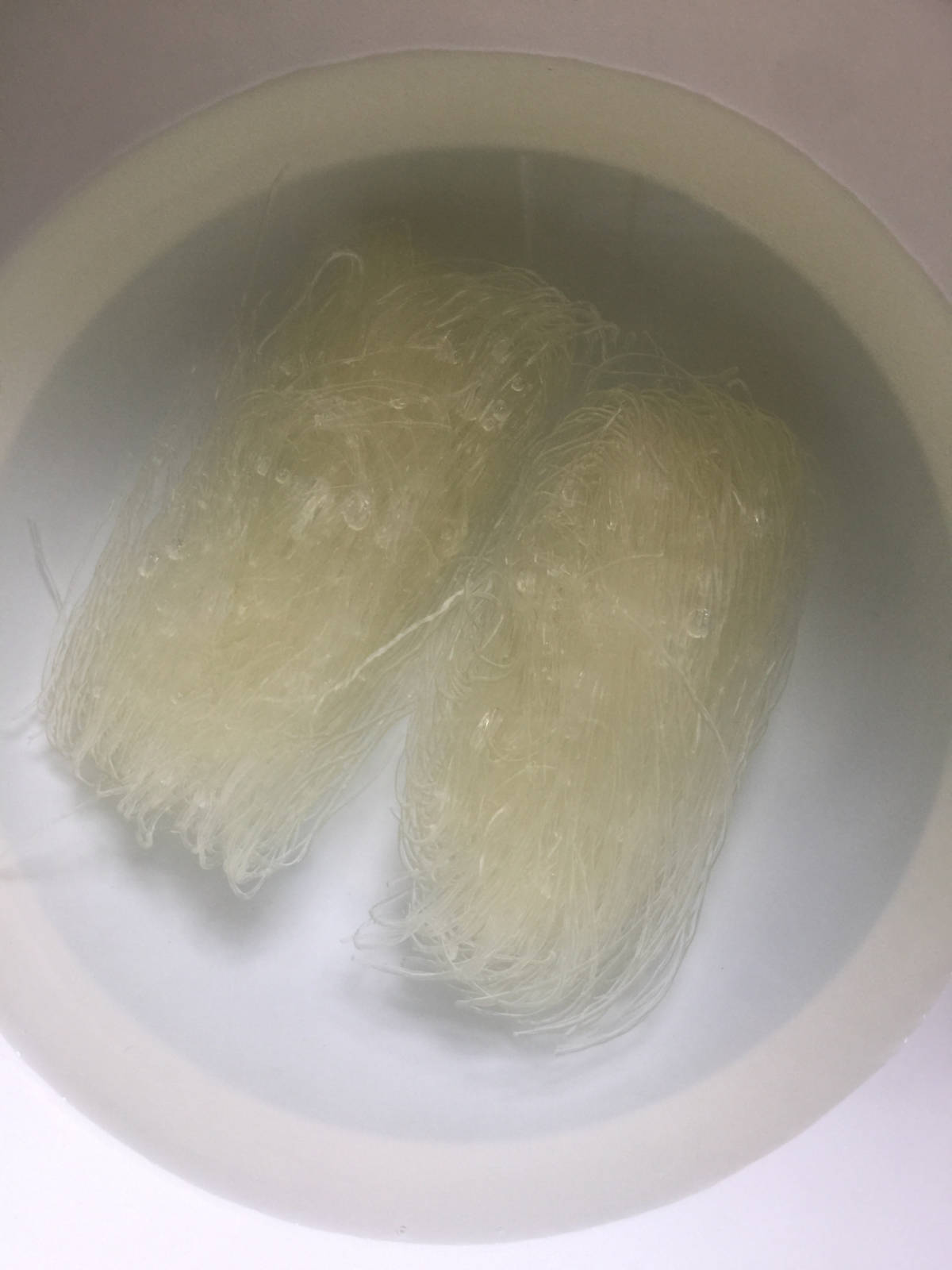 2 small bunches of vermicelli noodle soaked in water in a white container