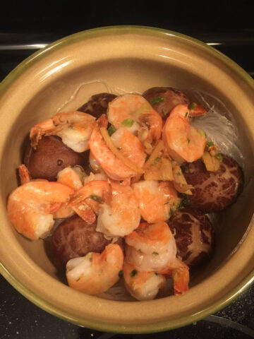 cooked shrimps, mushrooms and vermicelli noodles in clay pot with dressing