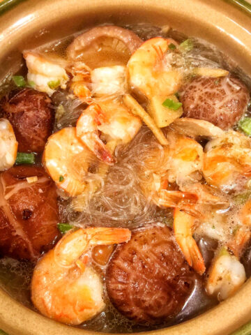 cooked vermicelli noodles, mushrooms, shrimps in clay pot with soup