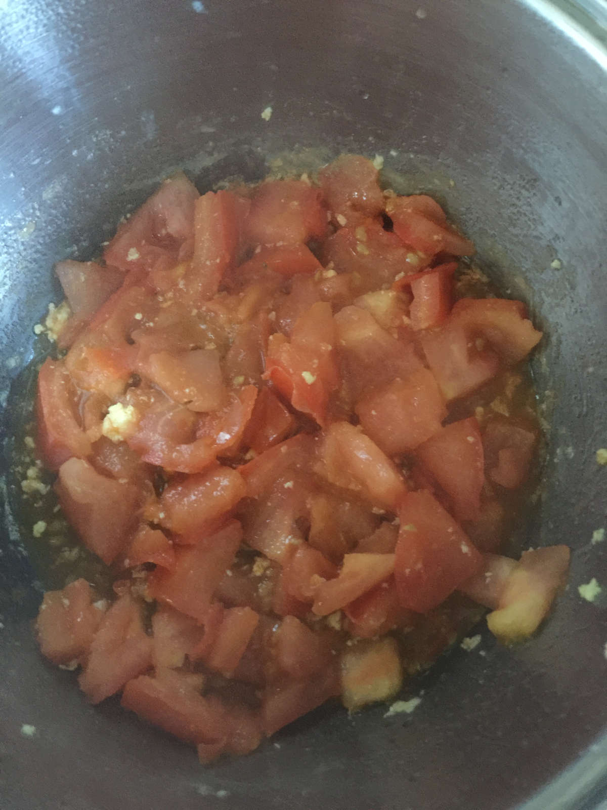 Tomato chunks cooked soft in wok