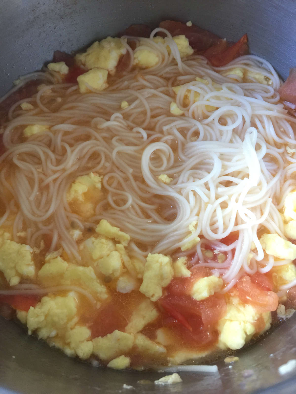 cooked noodles in tomato egg soup in pot