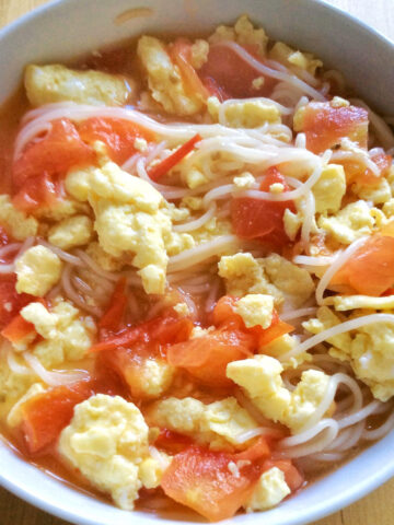 tomato egg noodle soup in a white bowl