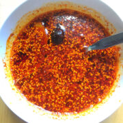 Overhead view of cooked homemade chili oil in a white bowl.