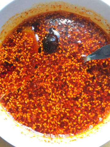 Overhead view of cooked homemade chili oil in a white bowl.