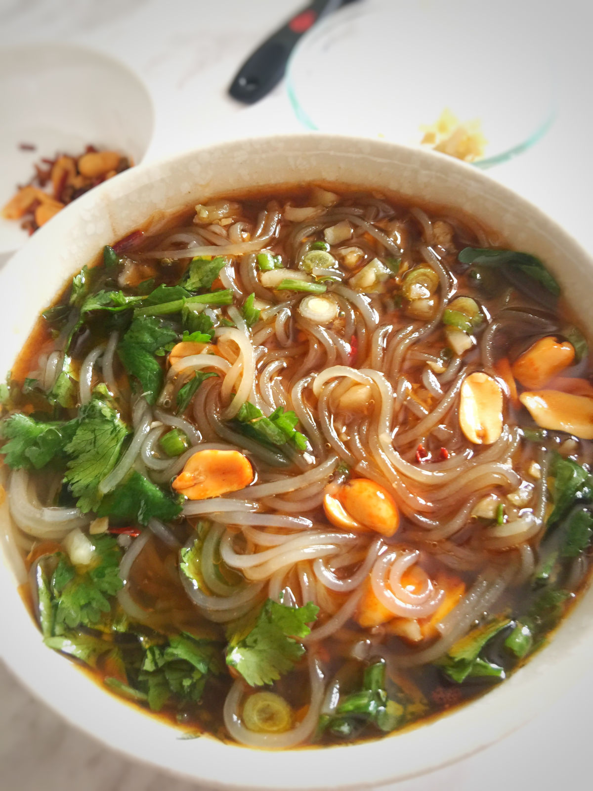 Close up view of a bowl of hot and sour glass noodle soup (suan la fen)