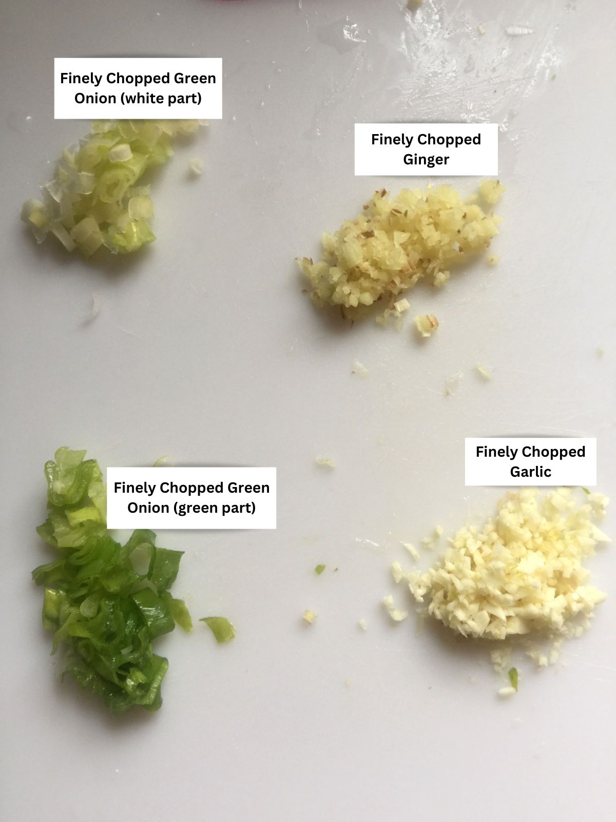 Labeled finely chopped green onion, ginger, and garlic.