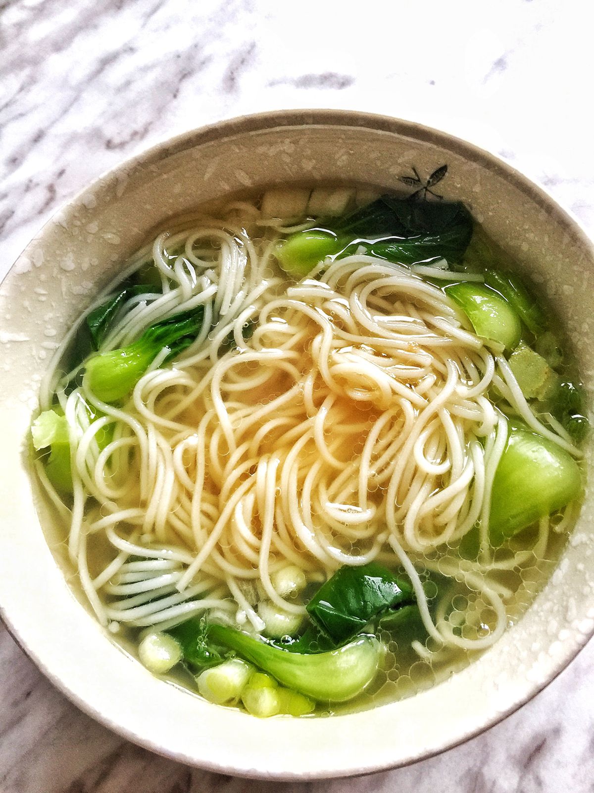 Overhead view of cooked noodle soup in a bowl.